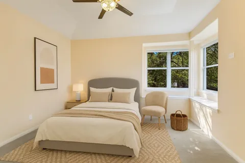 a bedroom with a bed and a large window