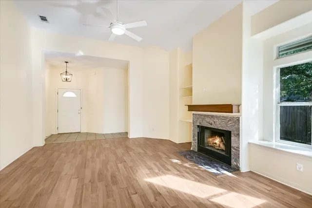 a view of empty room with wooden floor and fireplace