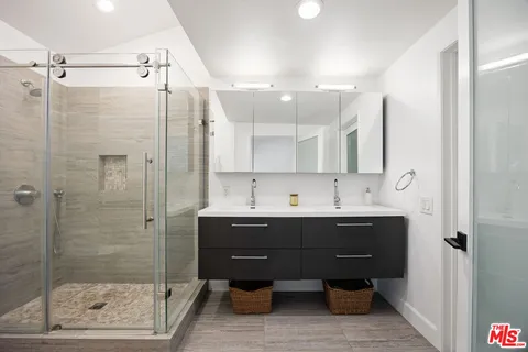 a bathroom with a sink mirror and a shower