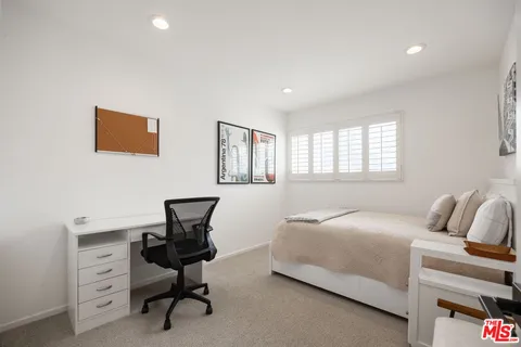 a bedroom with a bed and a desk