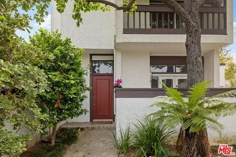 a front view of a house with plants