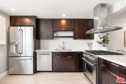 a kitchen with stainless steel appliances granite countertop a sink stove and refrigerator