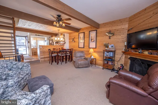 a living room with furniture a flat screen tv and floor to ceiling window