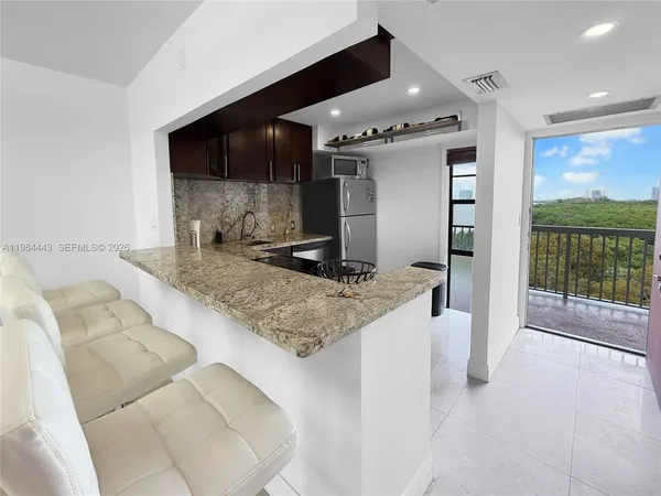 a large kitchen with granite countertop a sink and a stove top oven