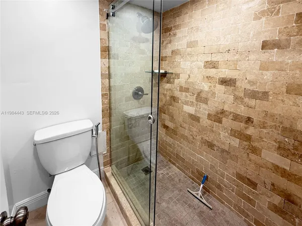 a bathroom with a granite countertop toilet sink and mirror