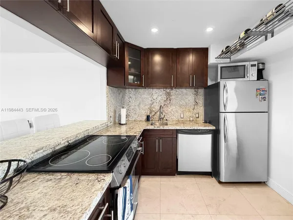 a kitchen with stainless steel appliances granite countertop a sink refrigerator and microwave