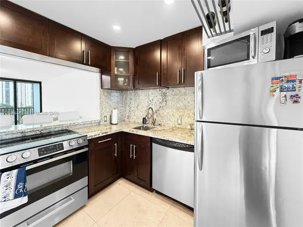 a kitchen with granite countertop stainless steel appliances and refrigerator