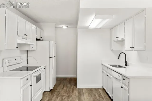 a kitchen with white cabinets and white appliances