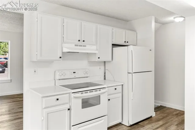 a kitchen with white cabinets and white appliances