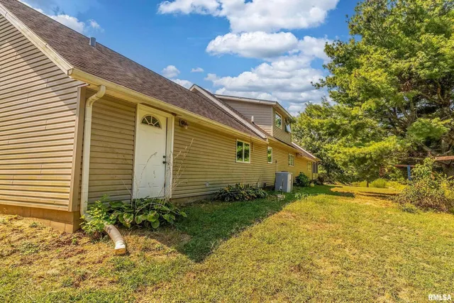 an aerial view of a house with a yard and mountain view in back
