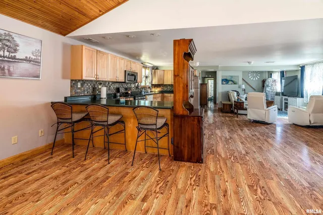 a kitchen with stainless steel appliances granite countertop a stove a sink dishwasher and a microwave oven with cabinets