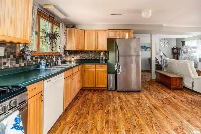 a kitchen with wooden floors wooden cabinets and stainless steel appliances