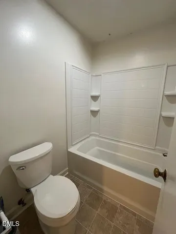 a white toilet sitting next to a bath tub