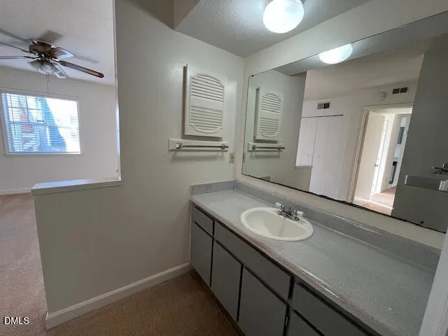 a bathroom with a granite countertop sink a toilet and a mirror