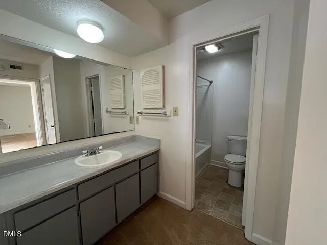 a spacious bathroom with a granite countertop sink mirror and toilet