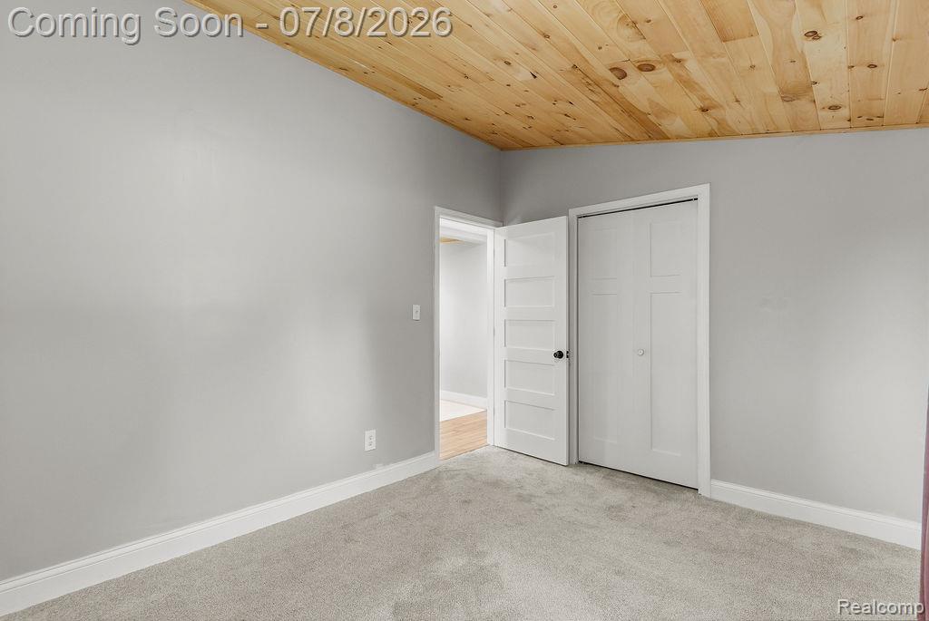 5698 McGrandy Road Bridgeport, MI 48722 - Photo 24 of 26 Room featuring a natural wood-panel ceiling, light gray walls, and light gray carpet flooring