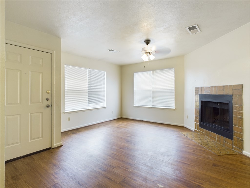 1221 April Bloom, Unit AB College Station, TX 77840 - Photo 14 of 31 an empty room with wooden floor chandelier and windows