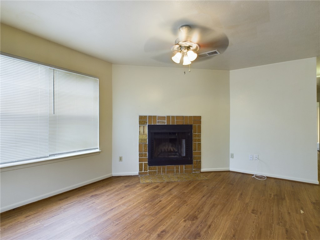 1221 April Bloom, Unit AB College Station, TX 77840 - Photo 3 of 31 an empty room with a fireplace and wooden floor