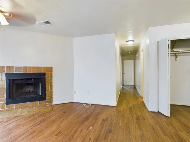 a view of empty room with wooden floor and fireplace
