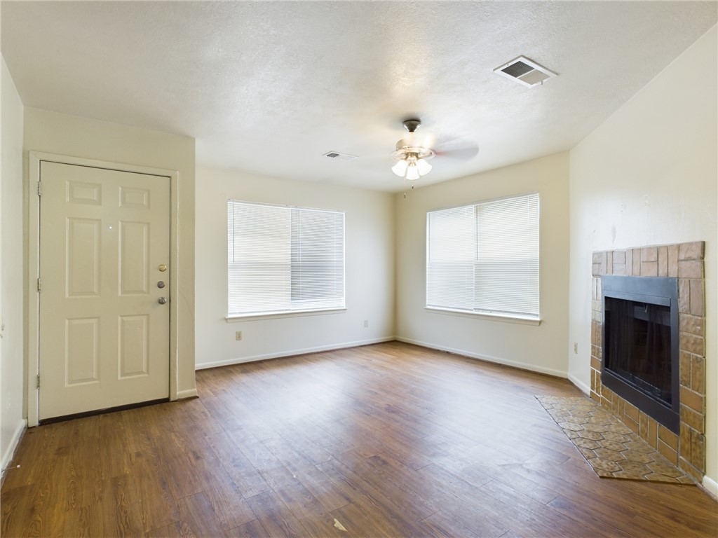 1221 April Bloom, Unit AB College Station, TX 77840 - Photo 8 of 31 an empty room with wooden floor fireplace and windows