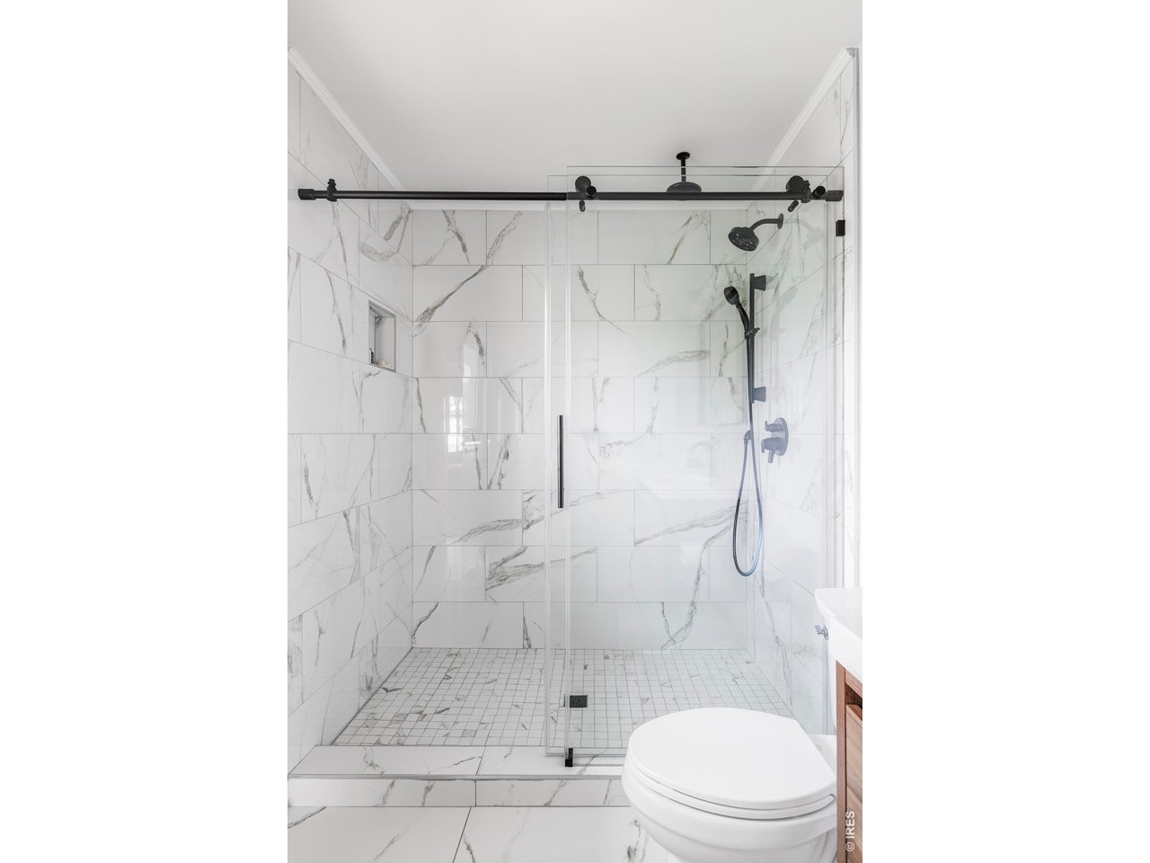 646 Furman Way Boulder, CO 80305 - Photo 14 of 38 The en-suite bathroom features a spacious walk-in shower with a rainfall shower head and modern finishes that mirror the home's overall design.