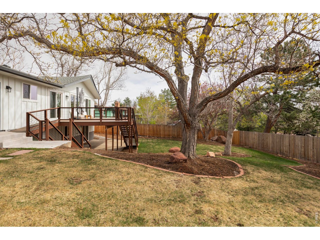 646 Furman Way Boulder, CO 80305 - Photo 35 of 38 The fully fenced yard is framed by mature trees, creating both privacy and usable space, while an attached two-car garage adds everyday convenience and practical storage.