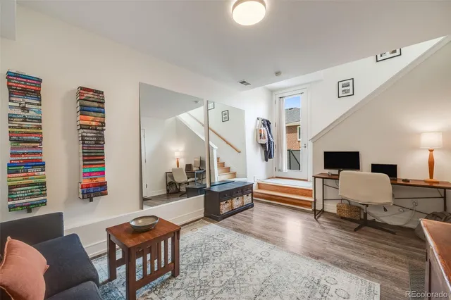 a living room with furniture and a wooden floor