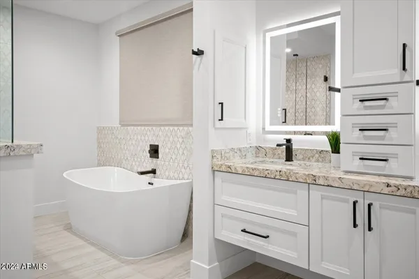 a bathroom with a granite countertop sink and a mirror