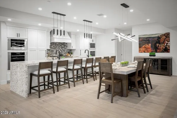 a kitchen with a table chairs microwave and cabinets