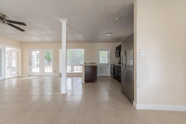a view of a big room with windows and kitchen view