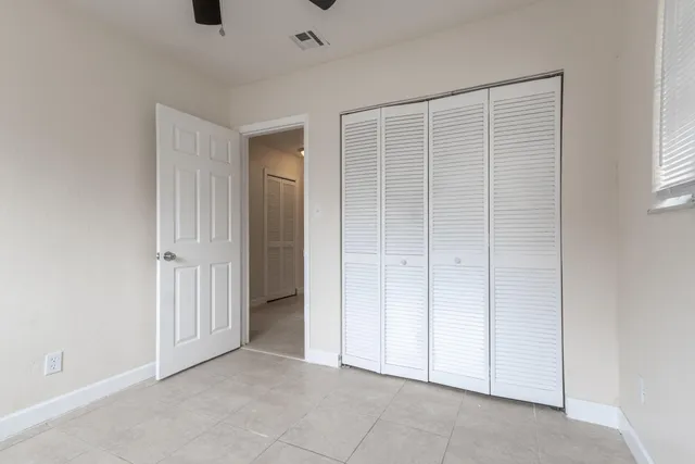 an empty room with windows and fan