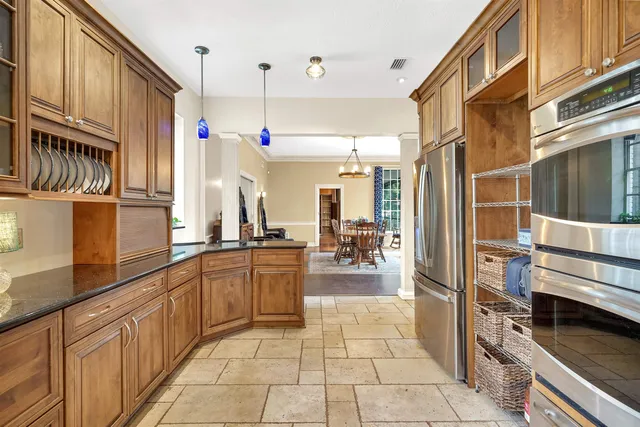 a kitchen with stainless steel appliances granite countertop a refrigerator and a stove