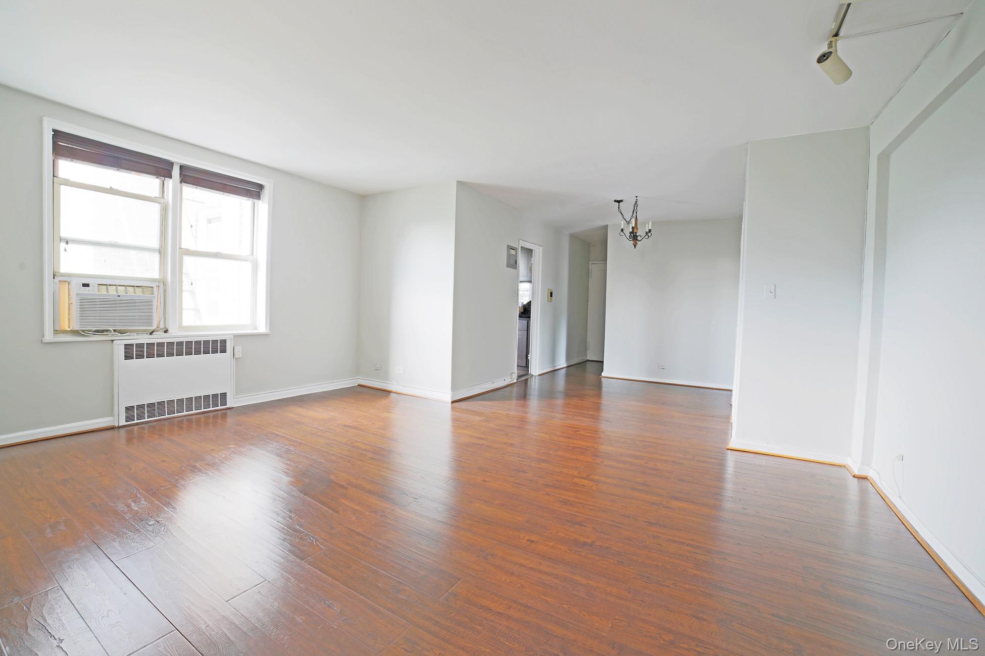 5621 Netherland Avenue, Unit 5C Bronx, NY 10471 - Photo 2 of 10 an empty room with wooden floor and windows
