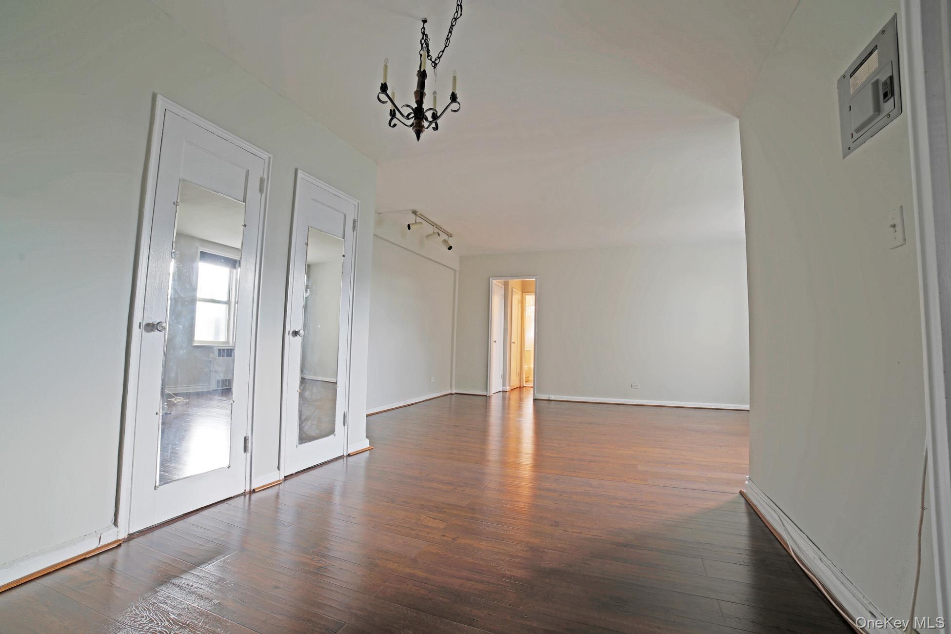 5621 Netherland Avenue, Unit 5C Bronx, NY 10471 - Photo 5 of 10 a view of an empty room with wooden floor and a window