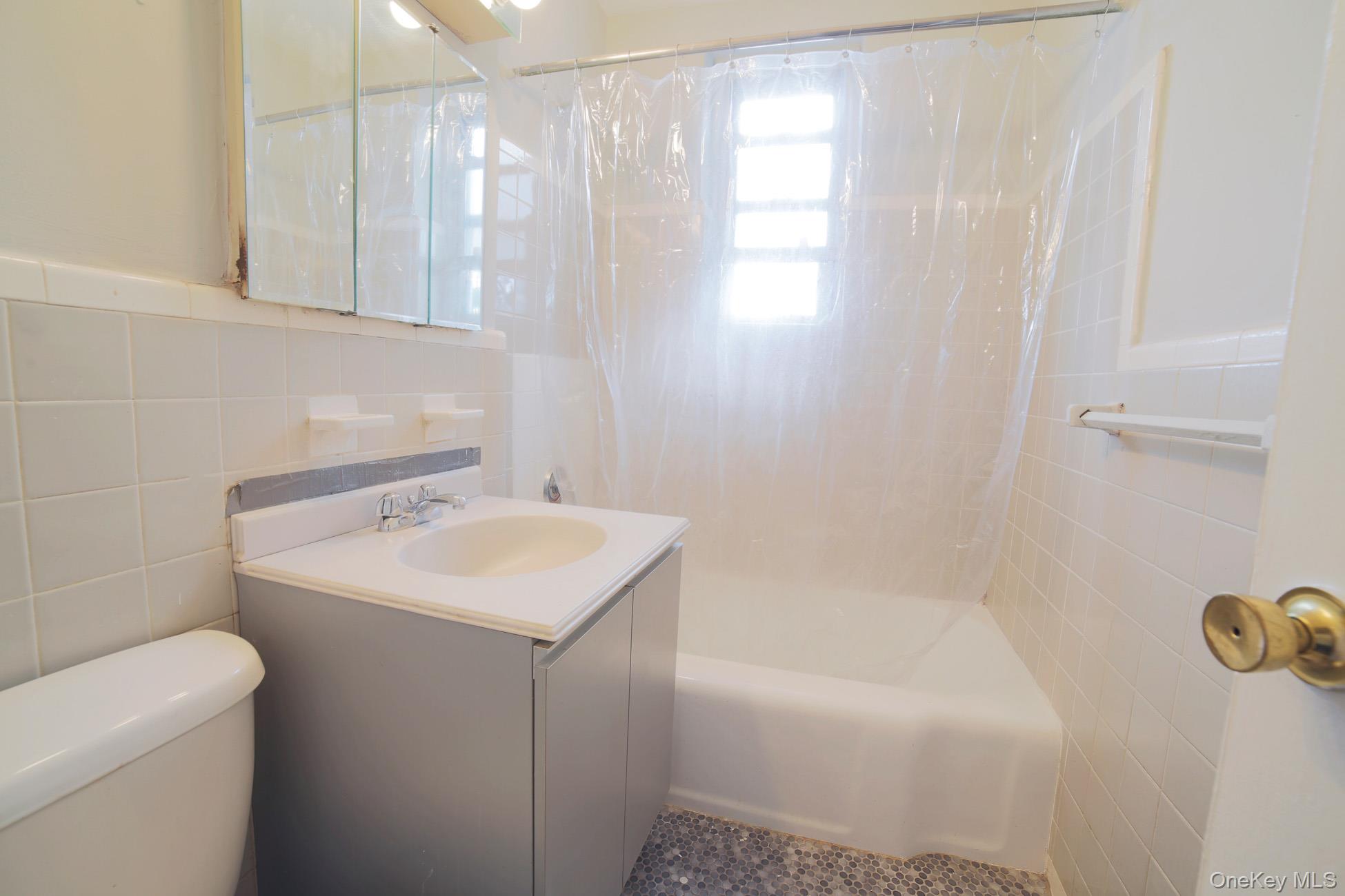 5621 Netherland Avenue, Unit 5C Bronx, NY 10471 - Photo 6 of 10 a bathroom with a sink a toilet and a bathtub