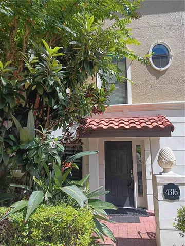 a front view of a house with a yard and potted plants