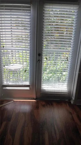 a view of a room with a large window and wooden floor