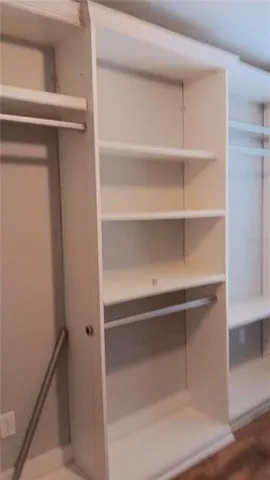 a room with walk in closet and wooden floor