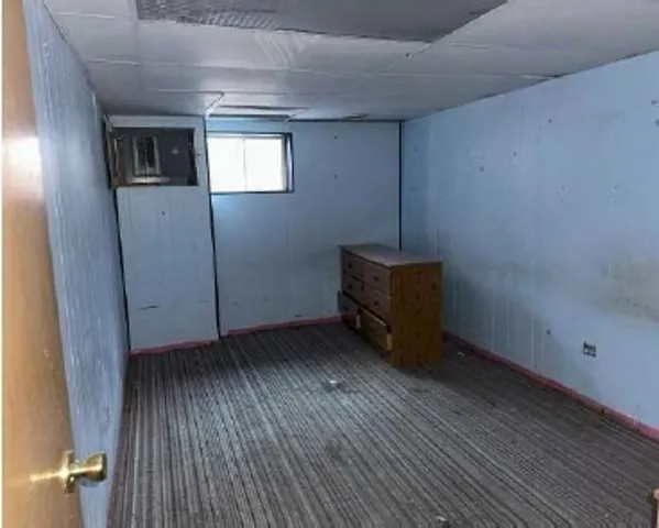 a room with wooden floor and window