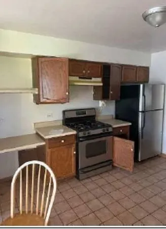 a kitchen with a stove a refrigerator and cabinets