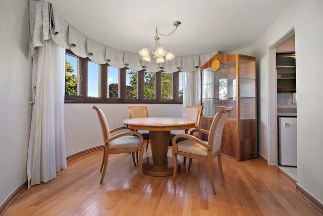 a view of a dining room with furniture a chandelier and wooden floor
