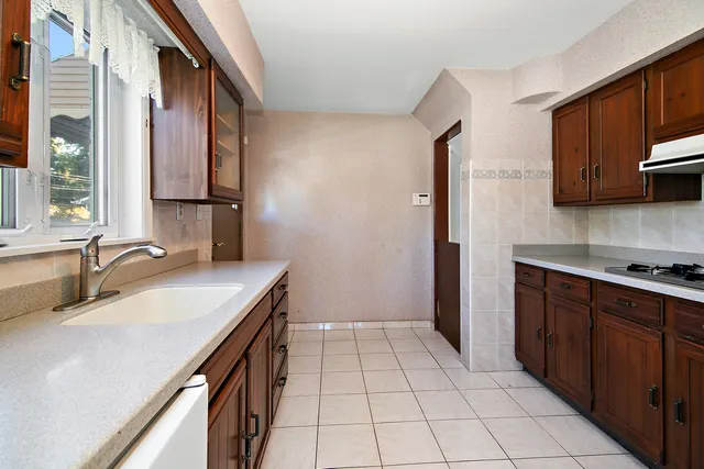a kitchen with a sink a stove cabinets and a wooden floor