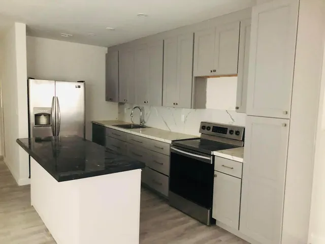 a kitchen with stainless steel appliances granite countertop a sink stove and refrigerator