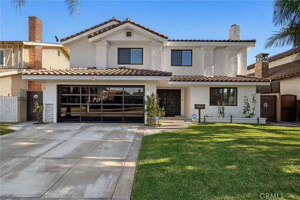 a front view of a house with a garden and yard