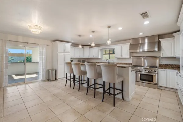 a kitchen with stainless steel appliances granite countertop a stove a sink and a refrigerator
