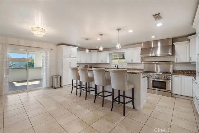 a kitchen with stainless steel appliances granite countertop a stove a sink and a refrigerator
