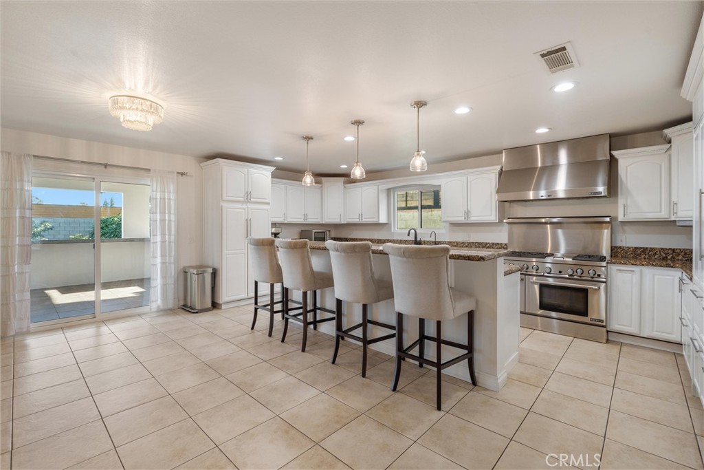 9434 Pico Vista Road Downey, CA 90240 - Photo 18 of 51 a kitchen with stainless steel appliances kitchen island granite countertop a table and chairs in it