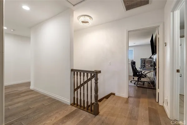 a bedroom with a large bed and wooden floor