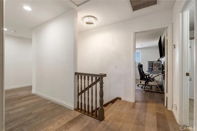 a bedroom with a large bed and wooden floor