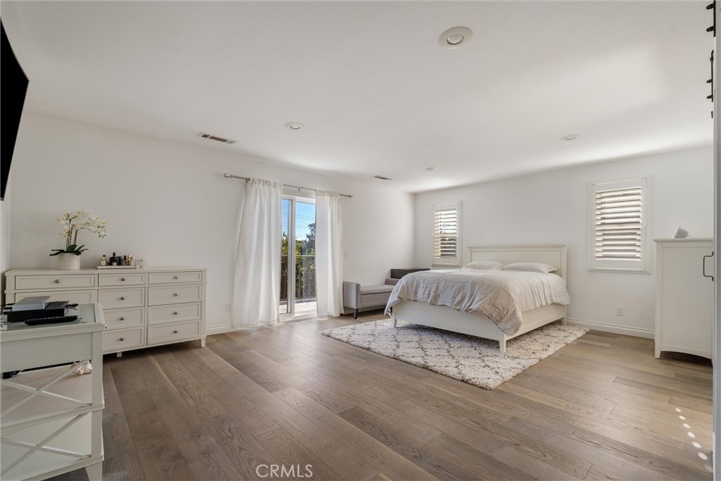 9434 Pico Vista Road Downey, CA 90240 - Photo 26 of 51 a bedroom with a large bed and wooden floor